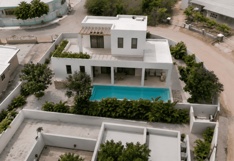 Luxe witte villa met privézwembad en tuin in een rustige woonwijk.