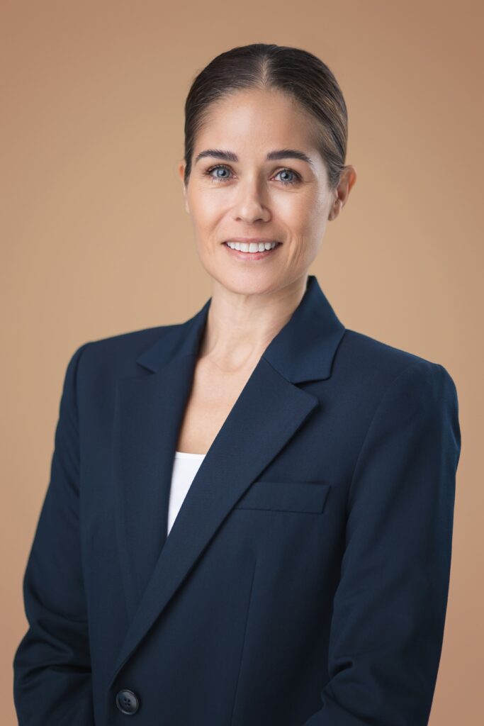 Vrouwelijke makelaar in zakelijke outfit voor Sunset Realtors.