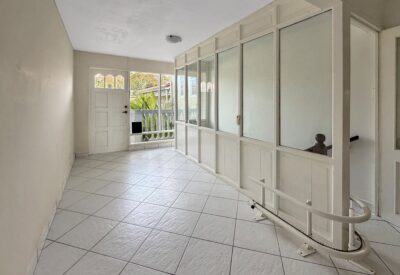 Ruime woonkamer met grote ramen en witte ingebouwde kasten, veel natuurlijk licht, geschikt voor won.