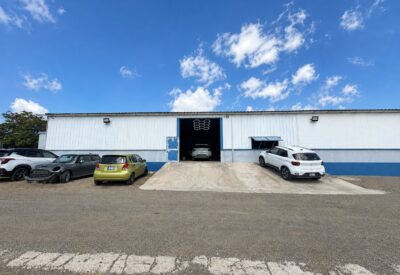 Opslaghal met verschillende auto's voor en naast de ingang in Willemstad.