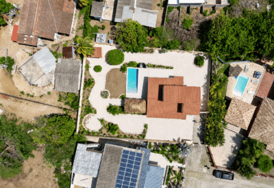 Luchtfoto van een modern huis met zwembad en tuin in een rustige buurt.