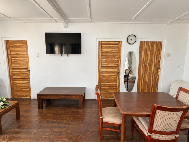 Gezellig woonkamerinterieur met houten deuren en een tv aan de muur.